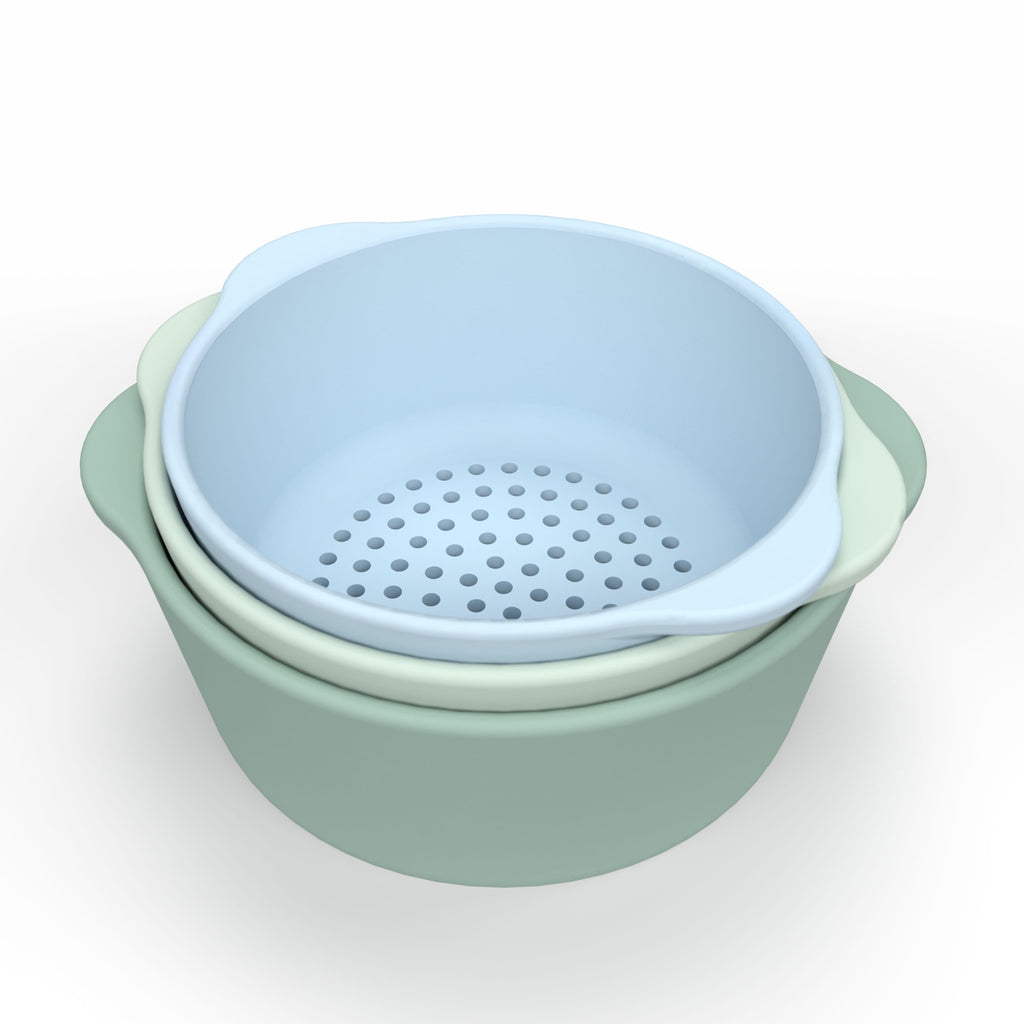 Three nested bowls in pastel colors: pale blue, mint green, and sage. The top blue bowl is perforated, suggesting it's a colander.