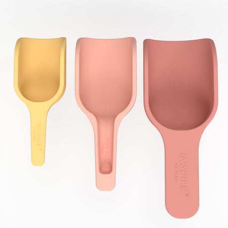 Three scoops in pastel colors—yellow, peach, and pink—are lined up in a row on a white background. They vary in size, conveying a playful tone.