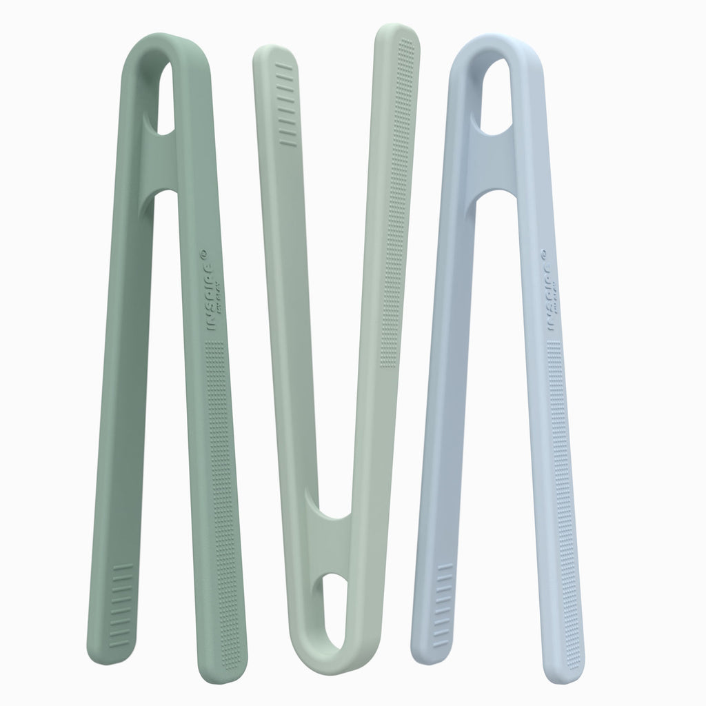 Three minimalist tongs in pastel green and blue shades are standing upright on a white background, displaying a sleek and modern design.