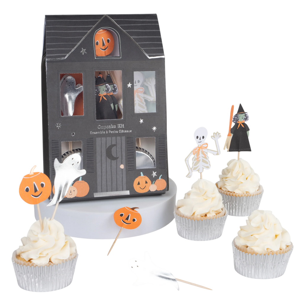 Halloween-themed cupcake kit with a haunted house box, ghost and pumpkin decorations, and four cupcakes topped with spooky character toppers.