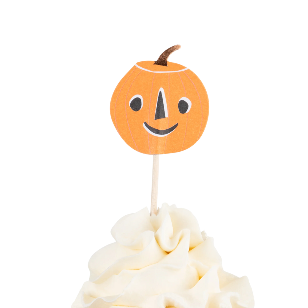 A cupcake topped with white frosting on a white background features a happy jack-o'-lantern topper, conveying a festive Halloween vibe.