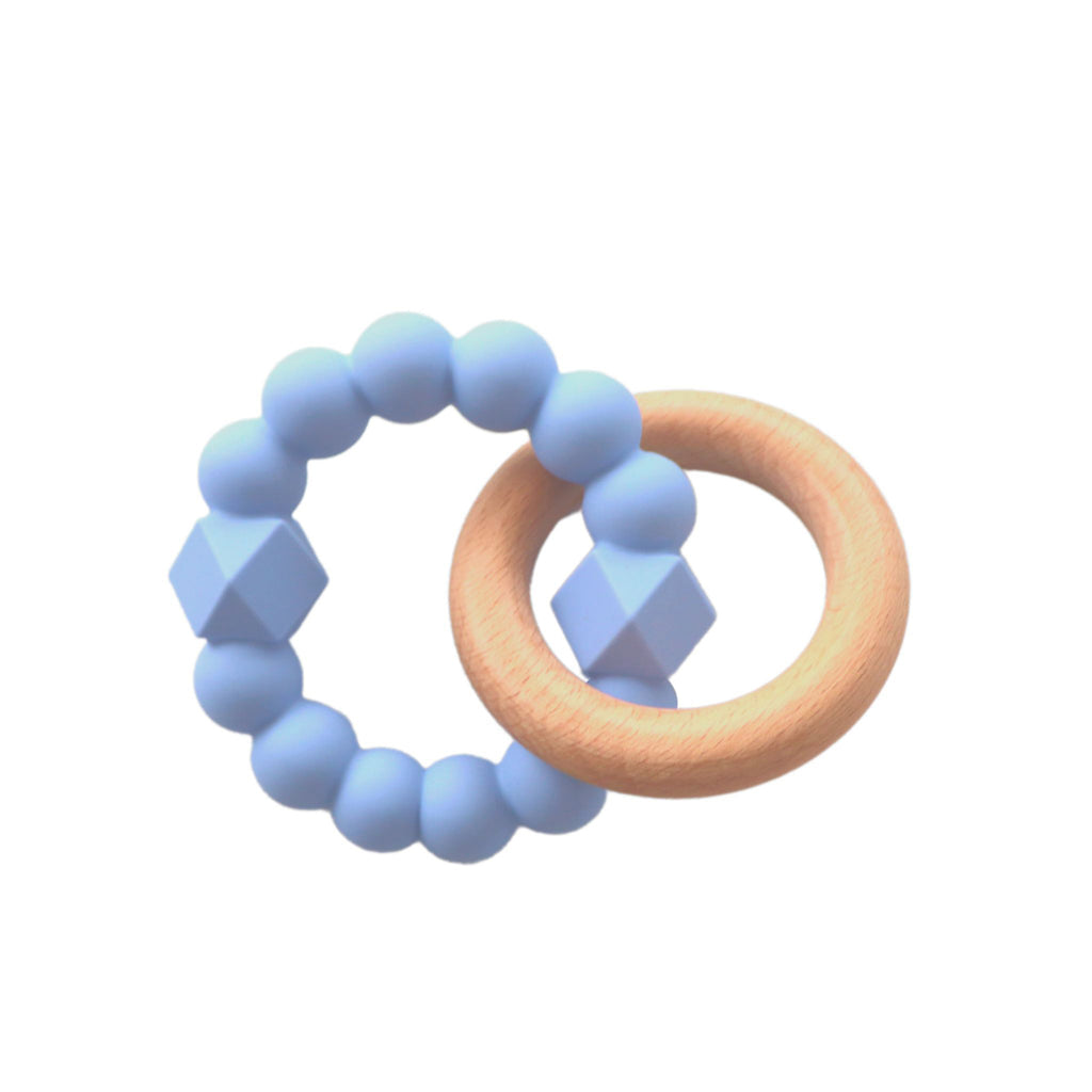 A soothing teething toy with a soft blue silicone beaded ring featuring geometric textures, paired with a natural wooden ring.