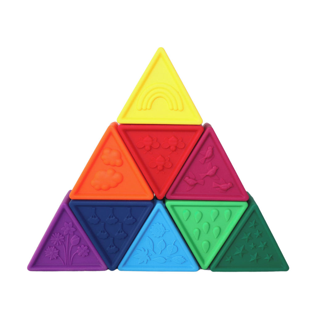 A stack of rainbow-coloured triangle blocks with embossed textures, including stars, rainbows, and flowers.