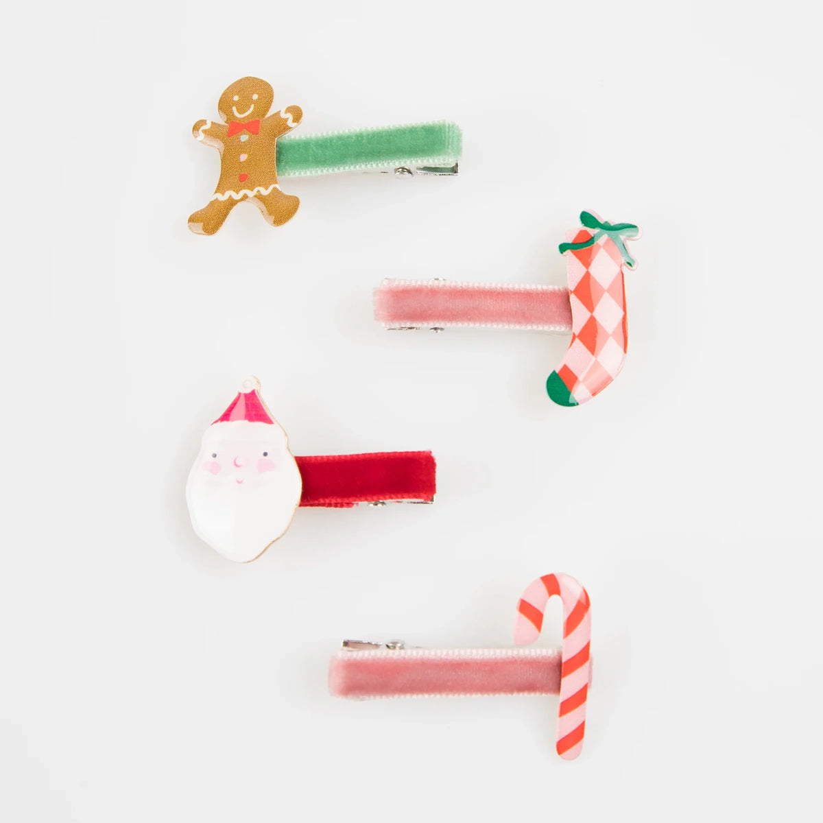 Four velvet Christmas hair clips featuring gingerbread man, stocking, Santa, and candy cane charms.
