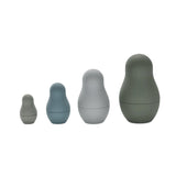 Four silicone nesting dolls in muted grey and blue tones lined up in a front view.