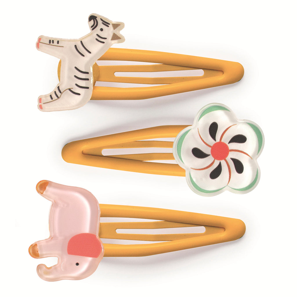 Three colorful hair clips on a white background, a zebra, a flower with red and green accents, and a pink elephant. The tone is playful and cute.