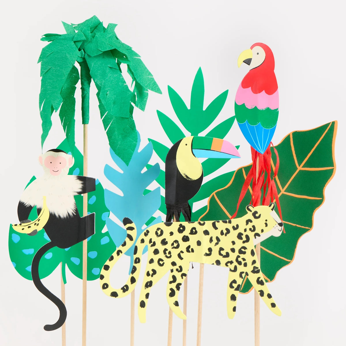Jungle-themed cake toppers featuring a monkey, toucan, leopard, parrot, palm tree, and colorful leaves.