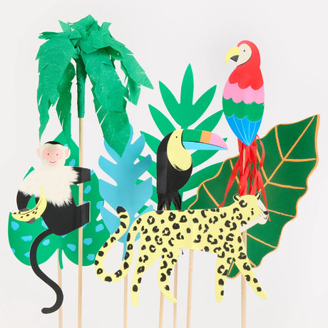 Jungle-themed cake toppers featuring a monkey, toucan, leopard, parrot, palm tree, and colorful leaves.