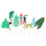 Jungle-themed paper cake toppers featuring a monkey, parrot, toucan, leopard, and various tropical leaves.
