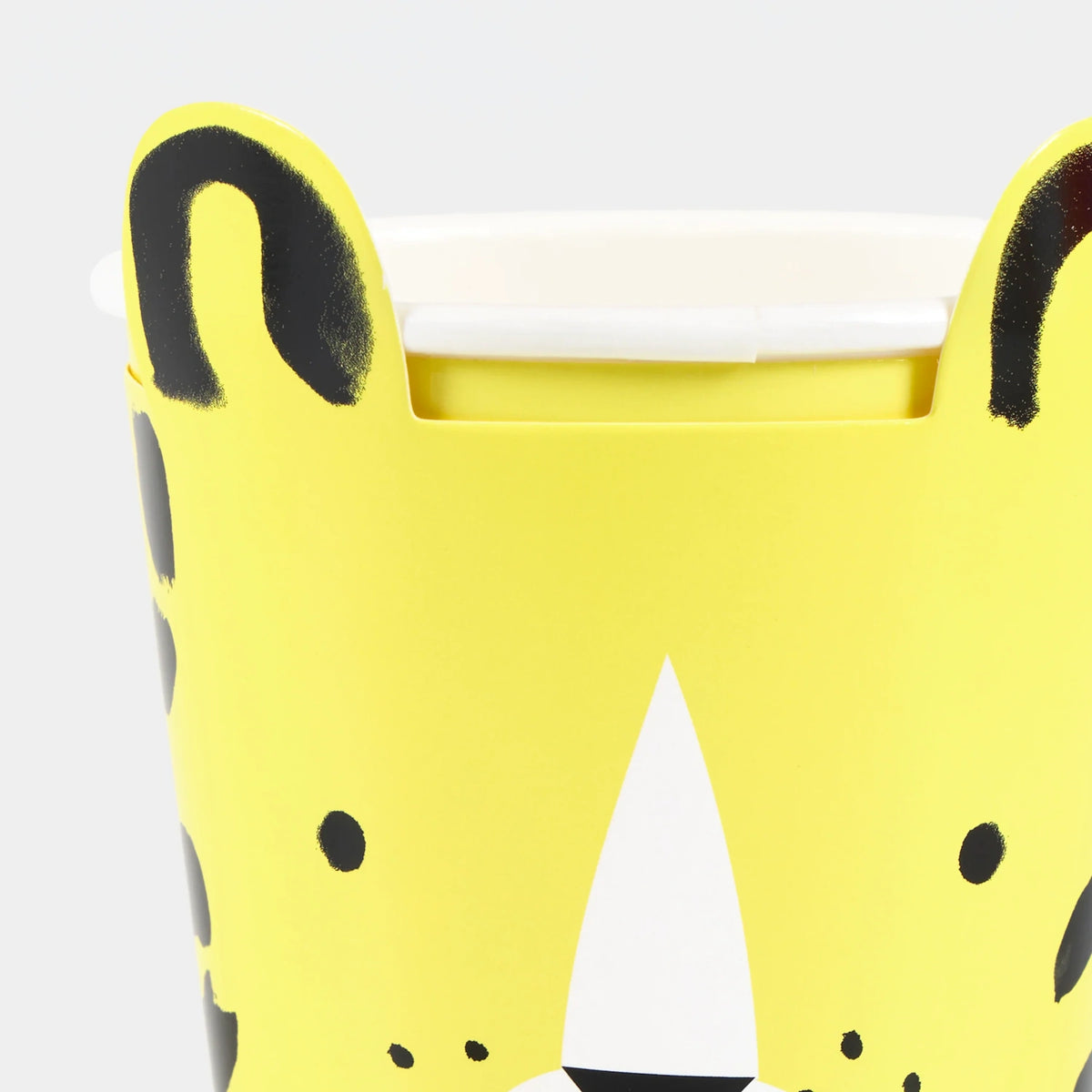 Close-up of a yellow animal-themed party cup with pop-out ears and black spots against a white background.