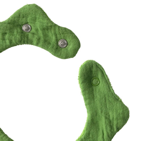 Close-up of a green muslin baby bib featuring adjustable snap fasteners on a white background.