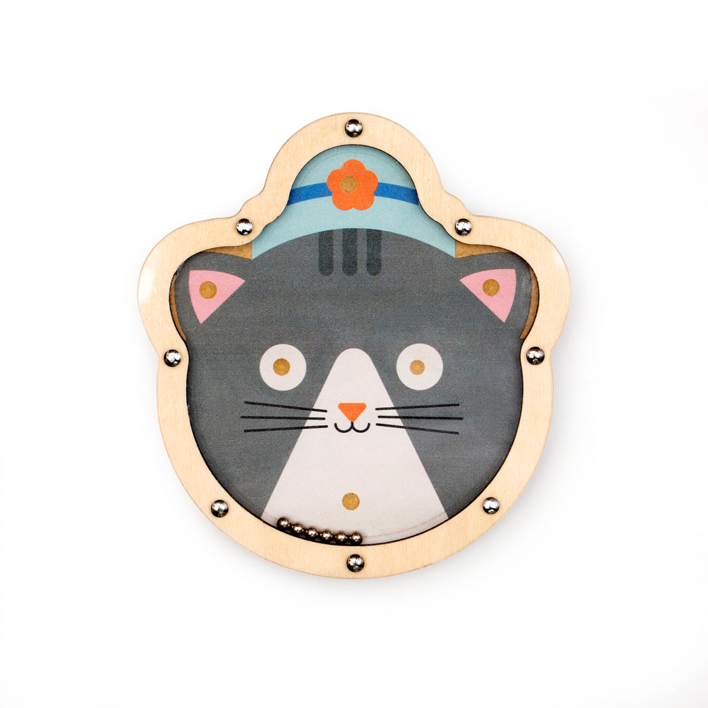 Wooden cat-shaped toy with a gray cat face wearing a blue hat with an orange flower. Its playful expression is framed by a light wood border.