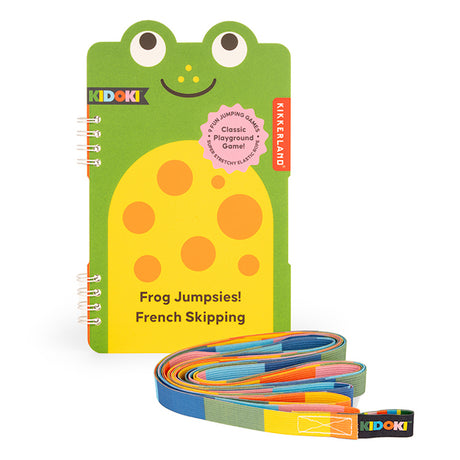 Playful frog-themed notebook with a smiling face, labeled "Frog Jumpsies! French Skipping" beside a colorful, coiled elastic jump rope. Vibrant, fun vibe.
