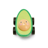 Toy car shaped like a cheerful avocado with a smiling pit face. The green body has four black wheels. Playful and whimsical tone.