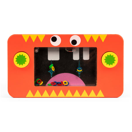 Toy water game with red monster design. Features a clear screen with colorful rings inside and two green buttons. Playful and fun mood.