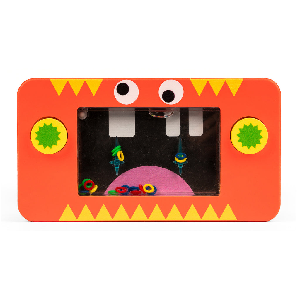 Toy water game with red monster design. Features a clear screen with colorful rings inside and two green buttons. Playful and fun mood.