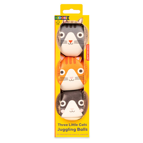 Yellow packaging shows three juggling balls with cute cat faces in gray, orange, and black. Text reads “Three Little Cats Juggling Balls.” Playful vibe.