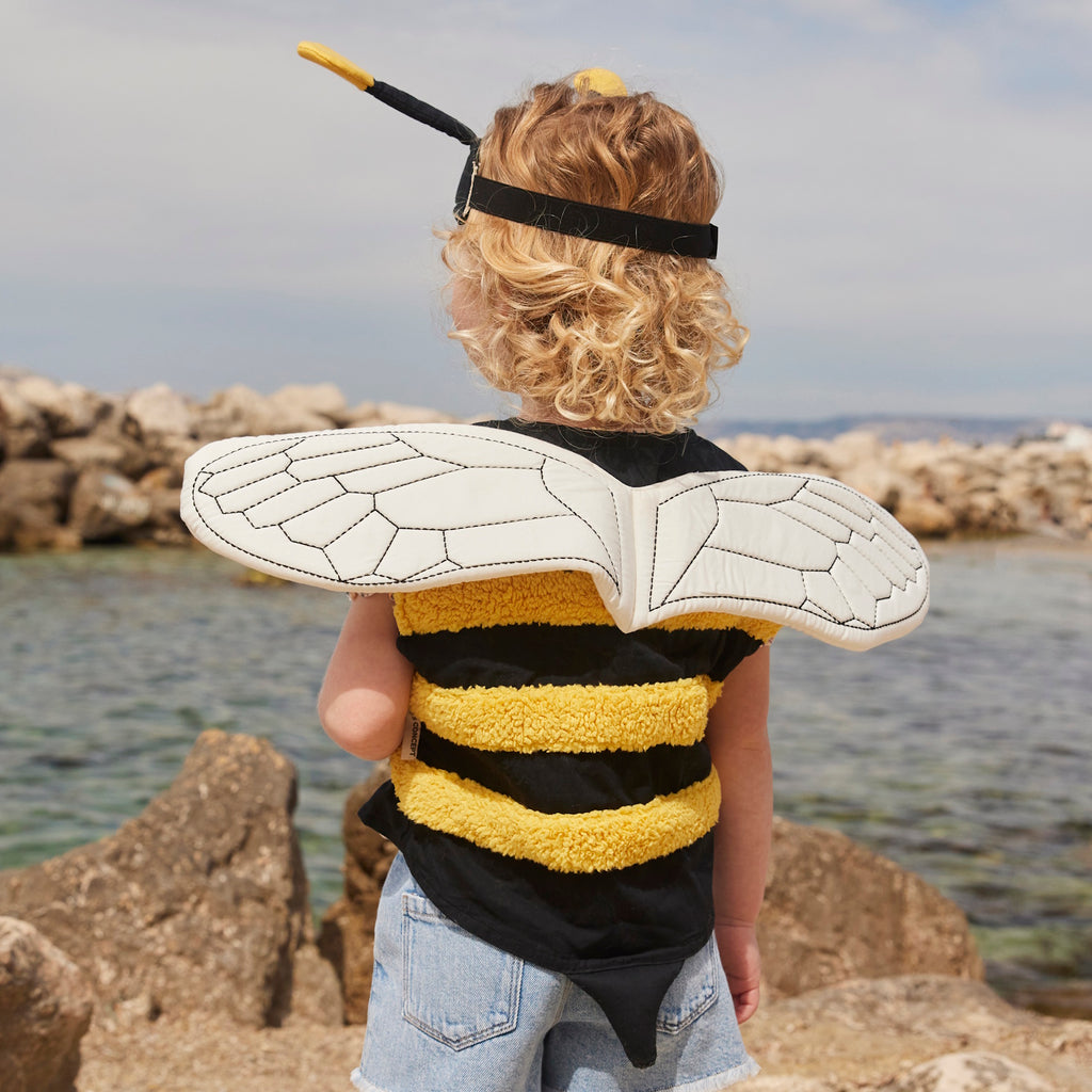 A playful bee costume for pets featuring yellow and black stripes, translucent wings with vein details, and a black headband with yellow pom antennas.