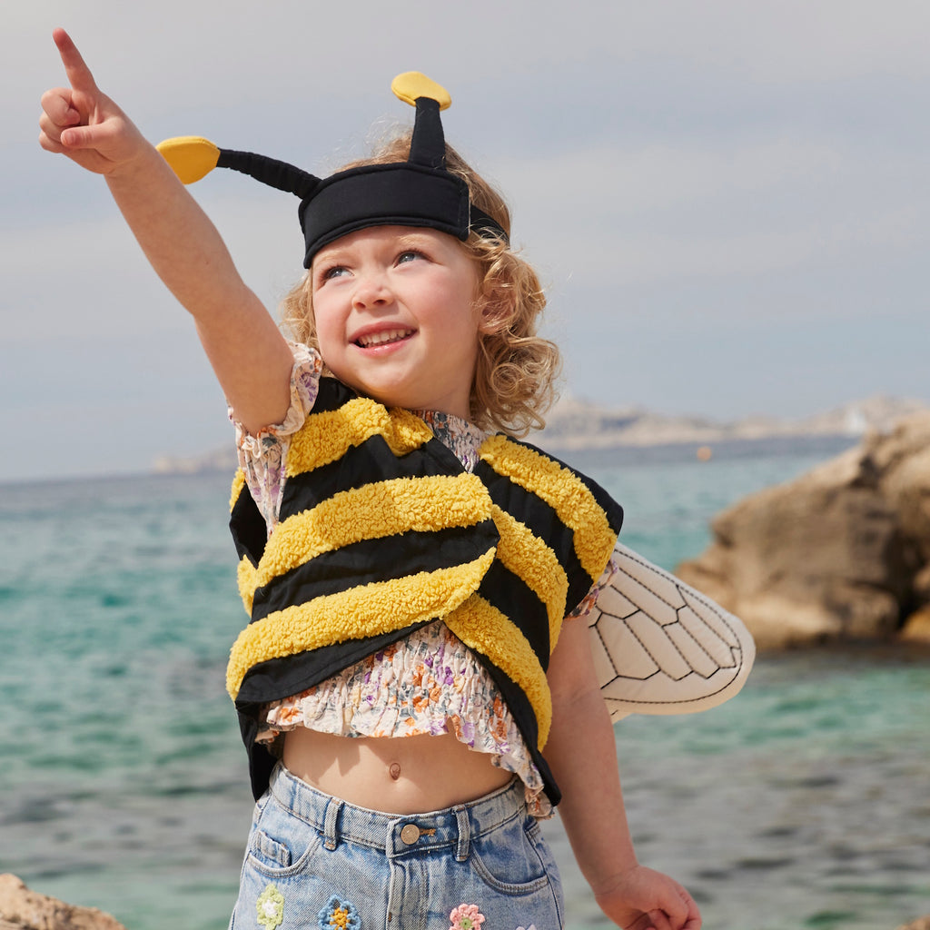 A playful bee costume for pets featuring yellow and black stripes, translucent wings with vein details, and a black headband with yellow pom antennas.