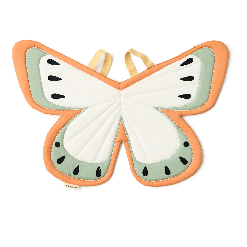 Fabric butterfly wings costume in soft orange, cream, and sage green with black teardrop accents. Two yellow straps suggest they can be worn. Bright and whimsical design.