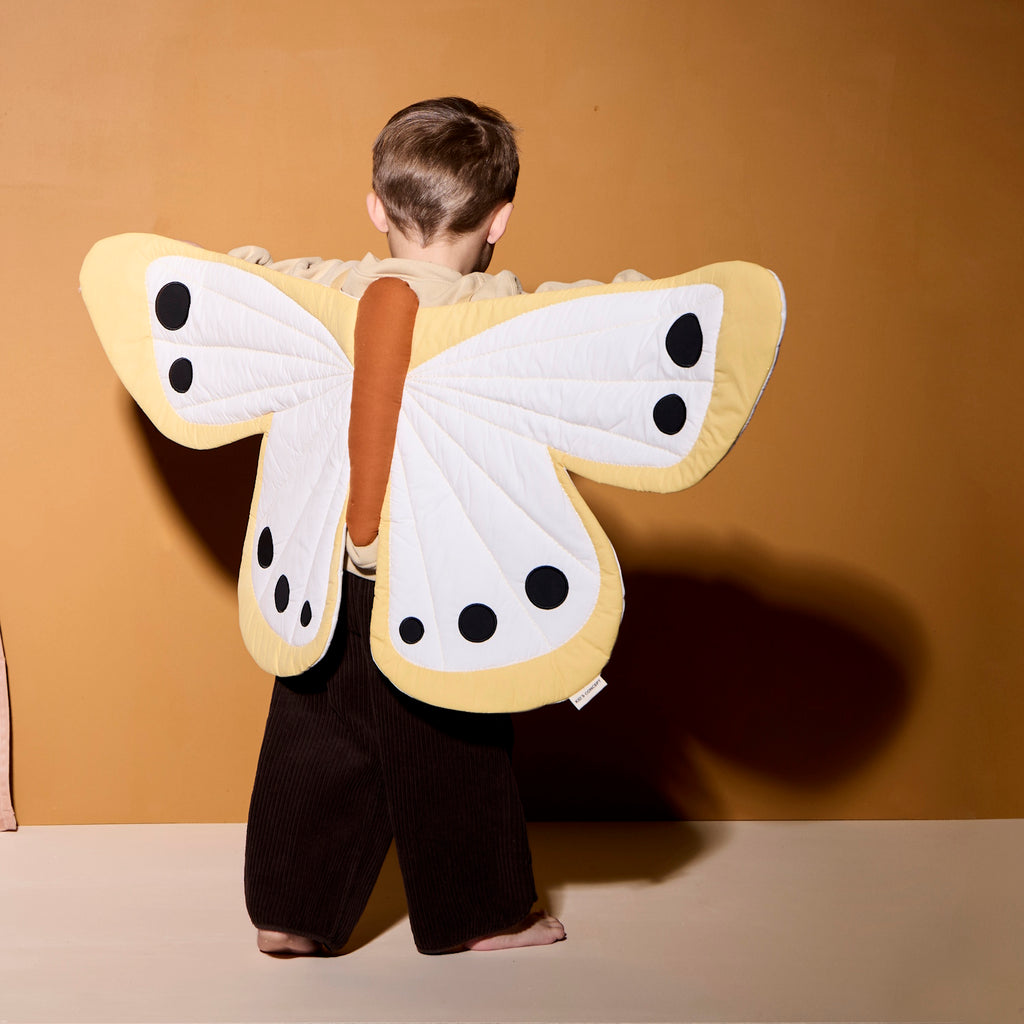 A cheerful yellow butterfly-shaped costume featuring black dots, perfect for imaginative play and decoration.