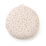 Round beige floor cushion with a subtle spotted pattern and carrying handle on a white background.