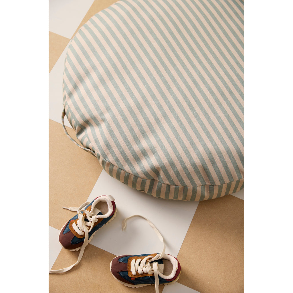 Round cushion with beige and gray horizontal stripes. The cushion has a calm, minimalist design, and includes a side handle.