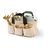 Canvas garden tool bag with green handles filled with toy gardening tools and plant markers.