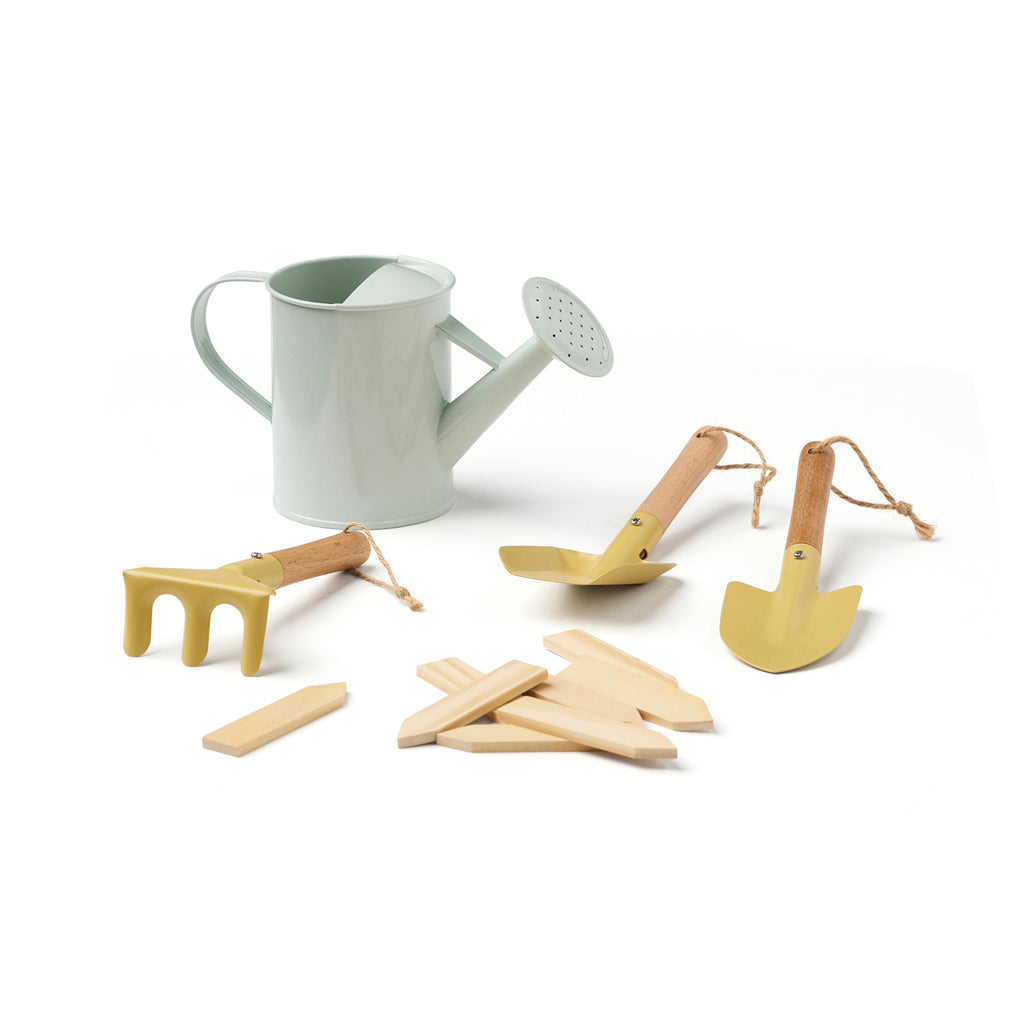 A mint green watering can with a spout, surrounded by a small yellow rake, two yellow hand trowels, and several wooden plant markers on a white background.