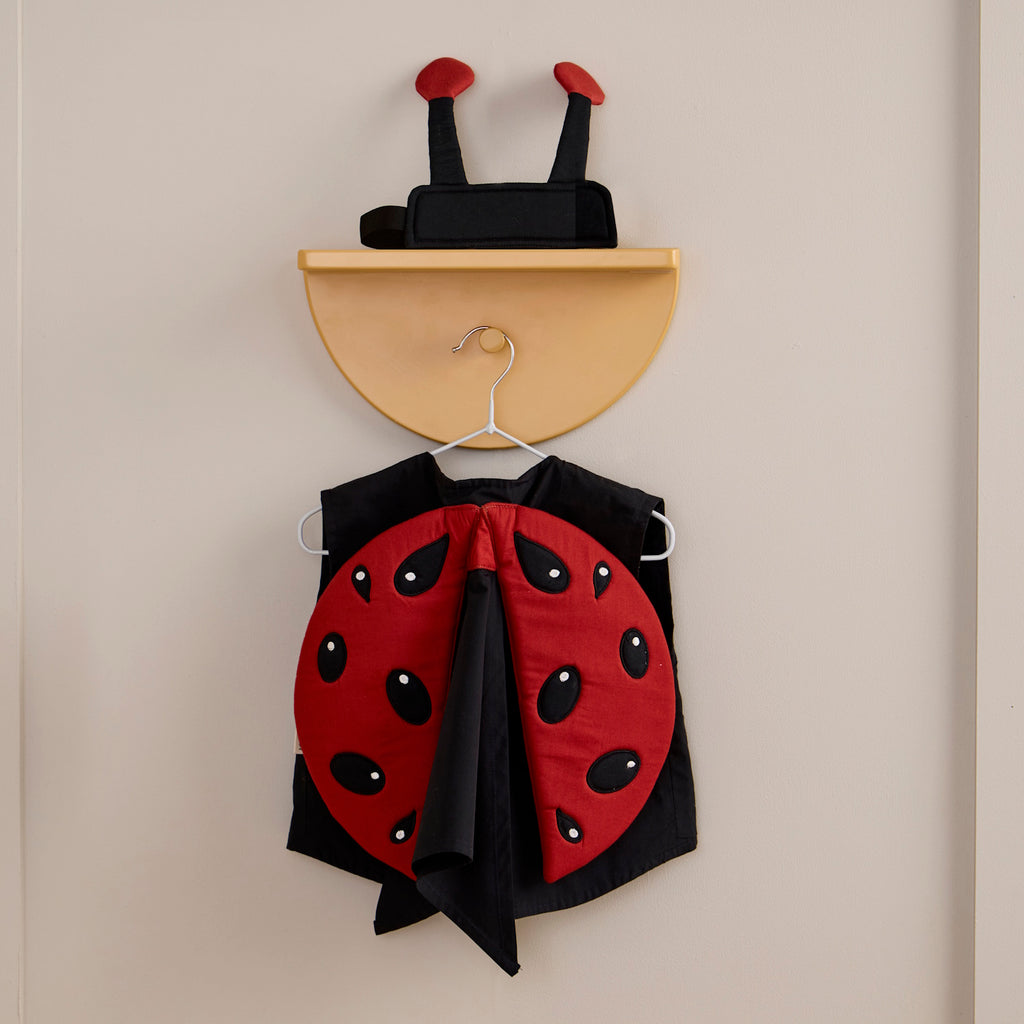 Children’s ladybug costume with a red shell featuring black spots and a matching headband with antennae.