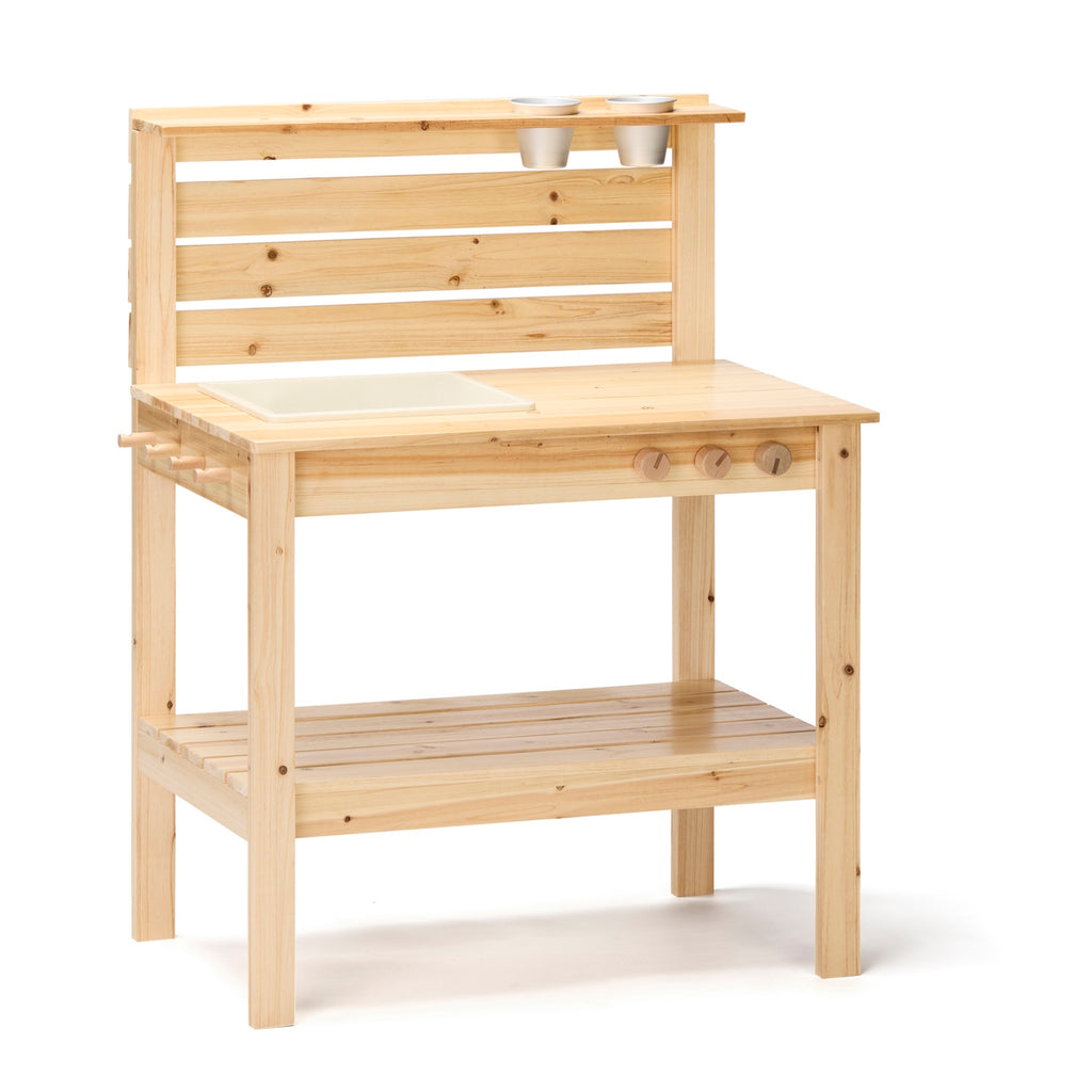 Wooden play kitchen with natural finish, featuring a countertop with a sink, knobs, and shelf. Pots hang from slats, conveying a playful, rustic charm.