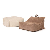 Off-white square Ottoman pouffe next to a brown corduroy floor lounge chair.