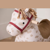Close-up of Kids Concept Dotty rocking horse head with beige spots, fringe mane, and red bridle.