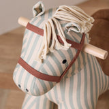 Close-up of the head and yarn mane of a striped fabric rocking horse toy.