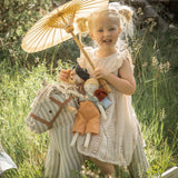Soft, striped rocking horse with a beige and blue pattern, wooden rockers, and a plush brown saddle. It evokes a playful, nostalgic feel.