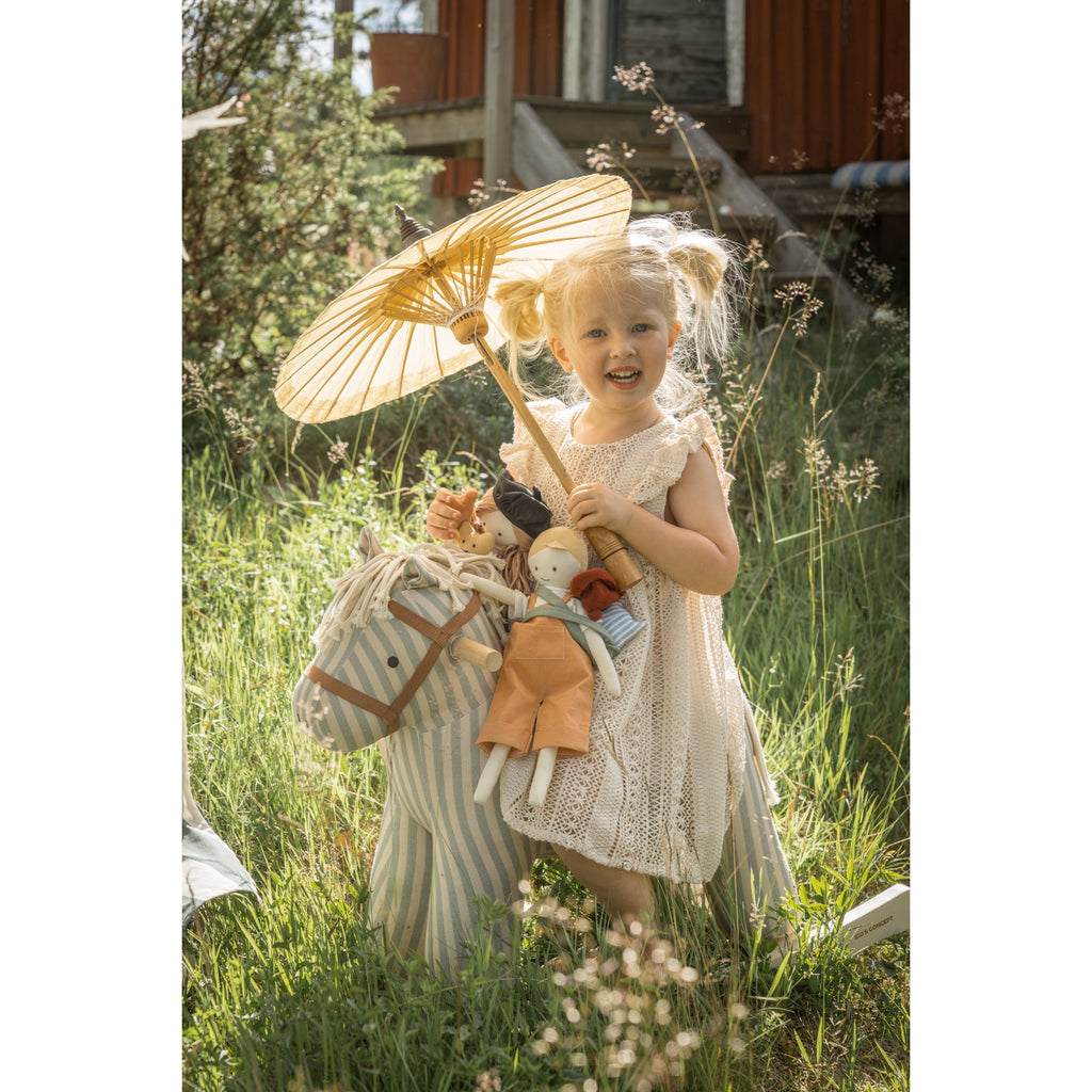 Soft, striped rocking horse with a beige and blue pattern, wooden rockers, and a plush brown saddle. It evokes a playful, nostalgic feel.