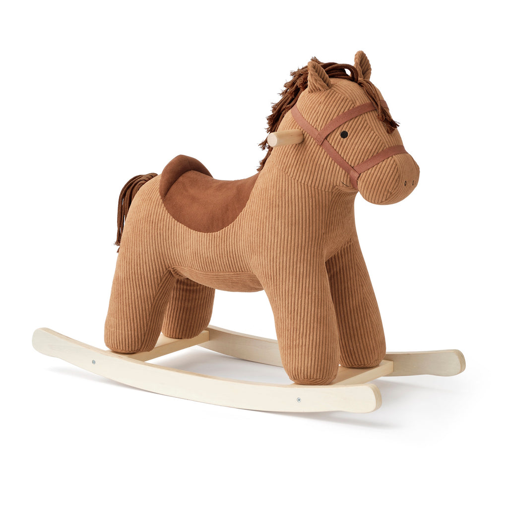 Plush rocking horse toy with a brown corduroy texture, wooden rocking base, and stitched details. The horse has a soft saddle and mane, evoking a cozy, playful feel.