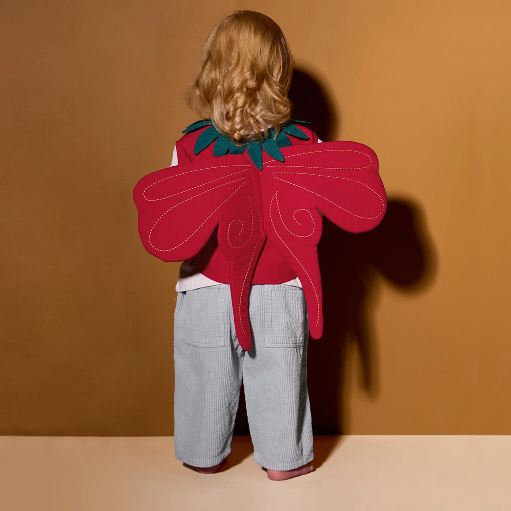 A vibrant red strawberry-themed costume set. It features a vest with green leaf accents and yellow seed details, a matching headband, and a wand. Perfect for playful dress-up.