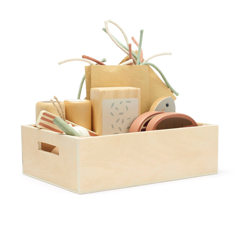 Wooden toy grocery set in a light wood crate, featuring toy food items and colorful string pasta. The playful design conveys creativity and fun.