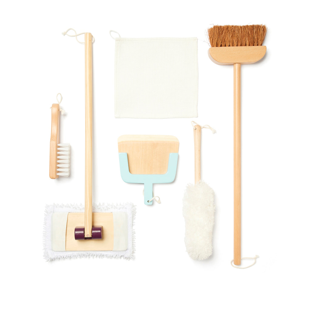 A collection of wooden cleaning tools including a broom, mop, and brushes. A cloth and duster are also shown. Neutral colors give a minimalist vibe.