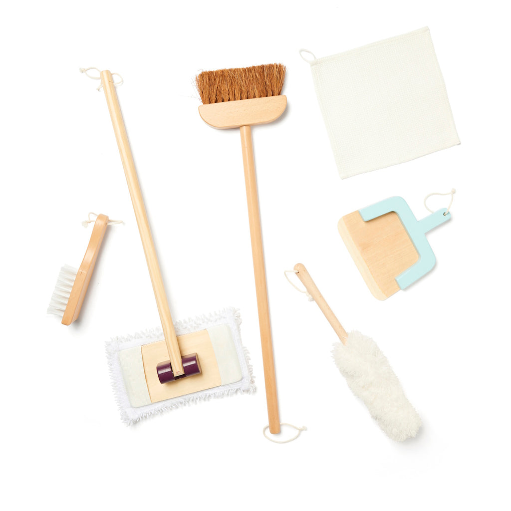 A collection of wooden cleaning tools including a broom, mop, and brushes. A cloth and duster are also shown. Neutral colors give a minimalist vibe.