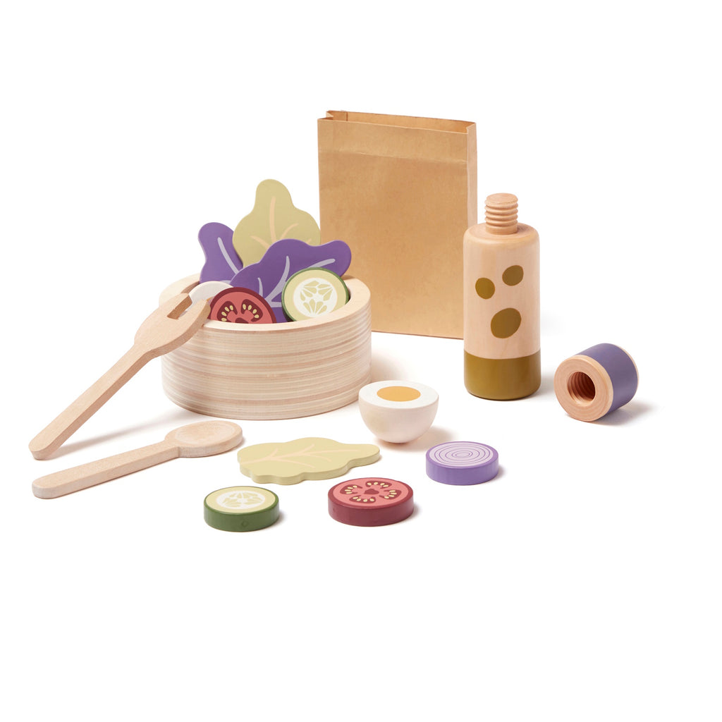 Wooden toy salad set with a bowl, utensils, slices of vegetables, and a bottle. Items are colorful, playful, and spread out, conveying a fun, culinary theme.