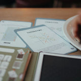 Educational game cards for children featuring a Tic-Tac-Toe grid with X and O marks on a wooden table.