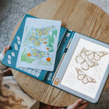 An illuminated drawing pad showing a butterfly sketch next to a finished, colored butterfly drawing.