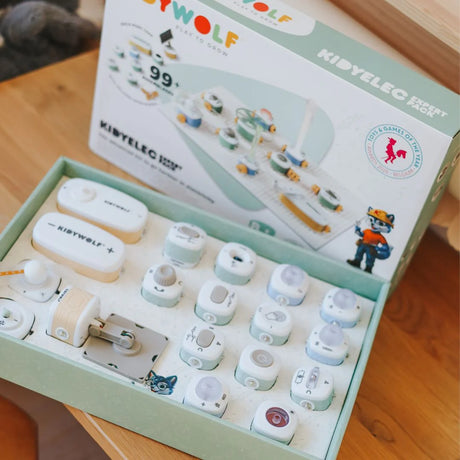 An open educational electronics toy kit box filled with various small building blocks and components.