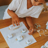 A child playing with an electronic toy circuit kit on a wooden table.