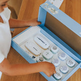 A child opens a Kidywolf electronics starter kit box filled with various modular components.