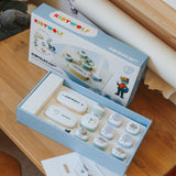 An open Kidywolf Kidyelec Starter Pack toy box on a wooden table, showing electronic building blocks inside.