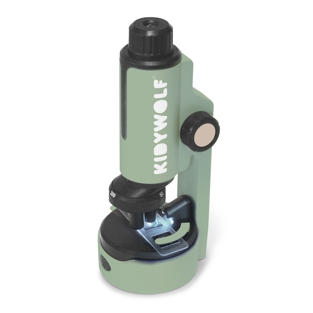 A compact green microscope labeled "KIDYWOLF" on a white background. It features a black rotating focus knob and an illuminated stage area.