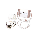 Cute camera with a smiling face and brown ears, surrounded by photo paper rolls, a striped strap, and photos, set against a white background.